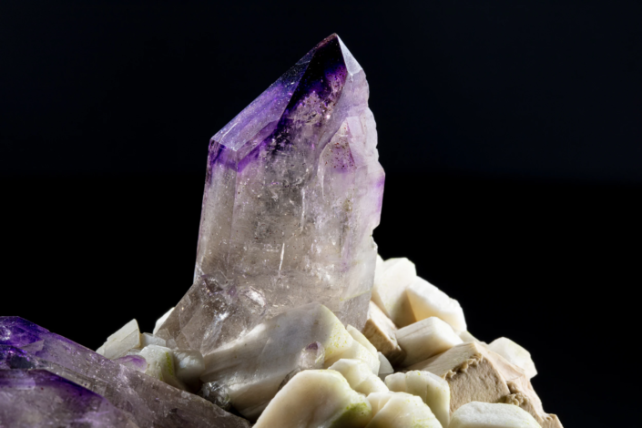 Amethyst crystal macro photograph — close-up of dominant crystal showing internal inclusions and color zoning