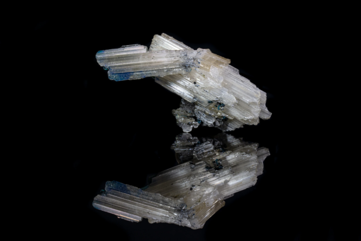 Cerussite and rosasite mineral specimen — full view on black mirror background showing prismatic cerussite crystals with blue rosasite patches, macro photography by Minerals Photography