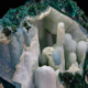 Chrysocolla coated by quartz — interior view showing full white quartz botryoidal cave structure with stalactites blue chrysocolla nodule and deep green exterior