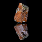Macro detail showing rhodochrosite crystals ranging from deep red to pale pink-salmon alongside white calcite blades, with dark gray matrix and yellow secondary mineral inclusions.