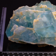 Blue-green fluorite cubic crystal cluster on calcite matrix with metric scale bar, mineral specimen measurement photography by Minerals Photography