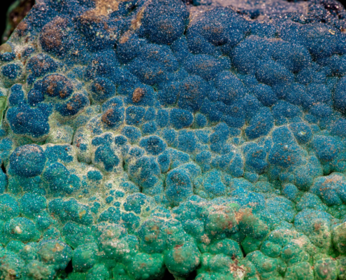 Deep blue sparkling cornetite mineral layer from Congo against black.